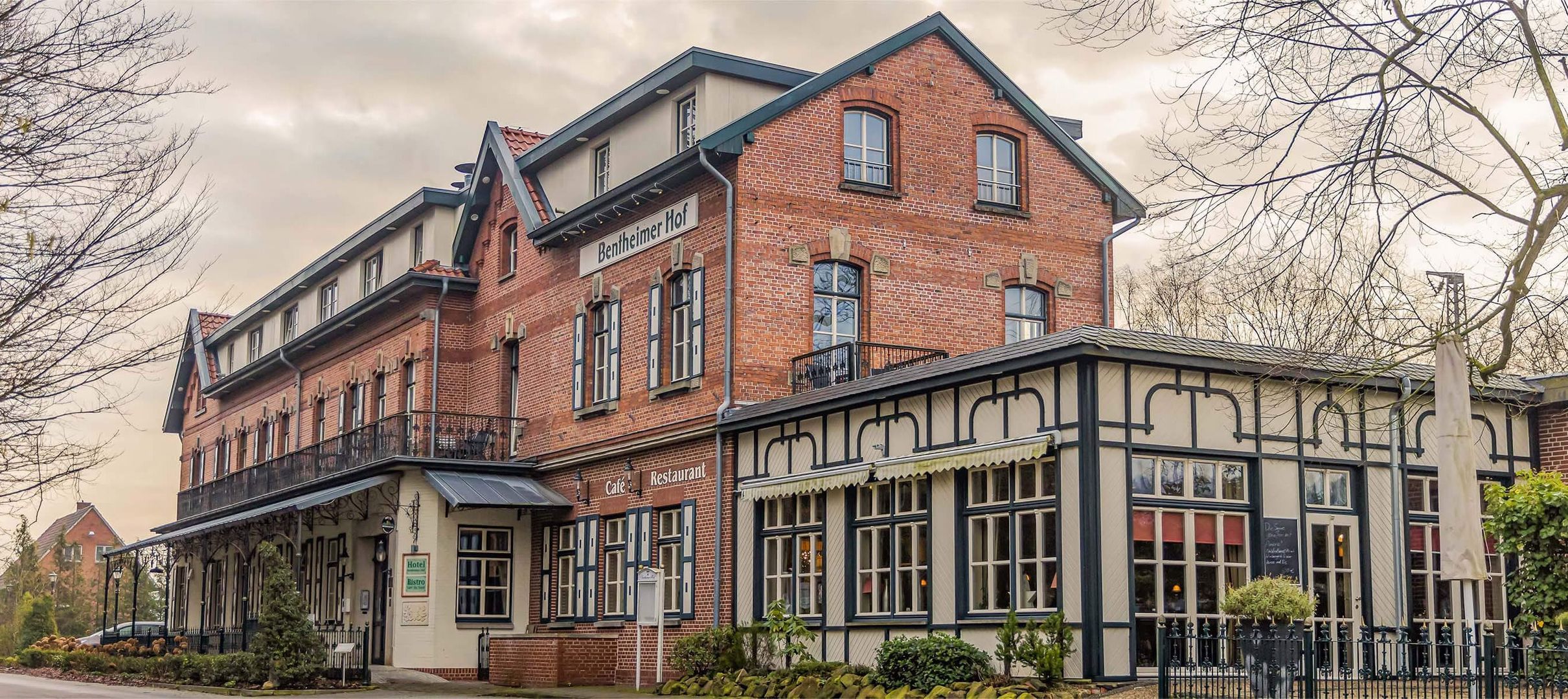 Backsteingebäude mit angebautem Wintergarten und Schild 'Bentheimer Hof' an der Fassade